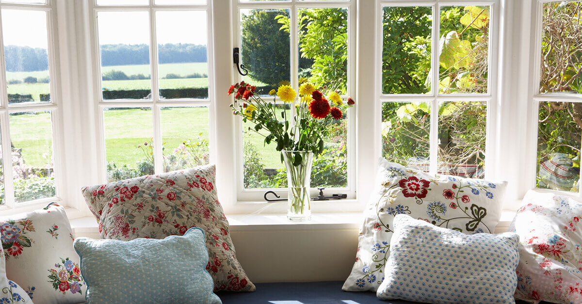 view to back yard through white bay windows